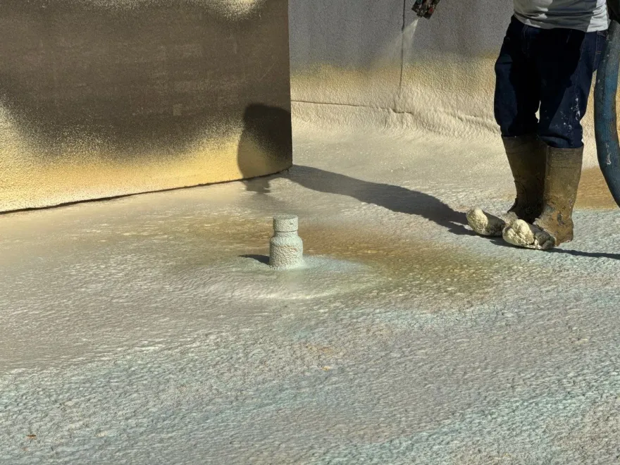 Fresh spray foam covering a commercial roof and running up its parapet.